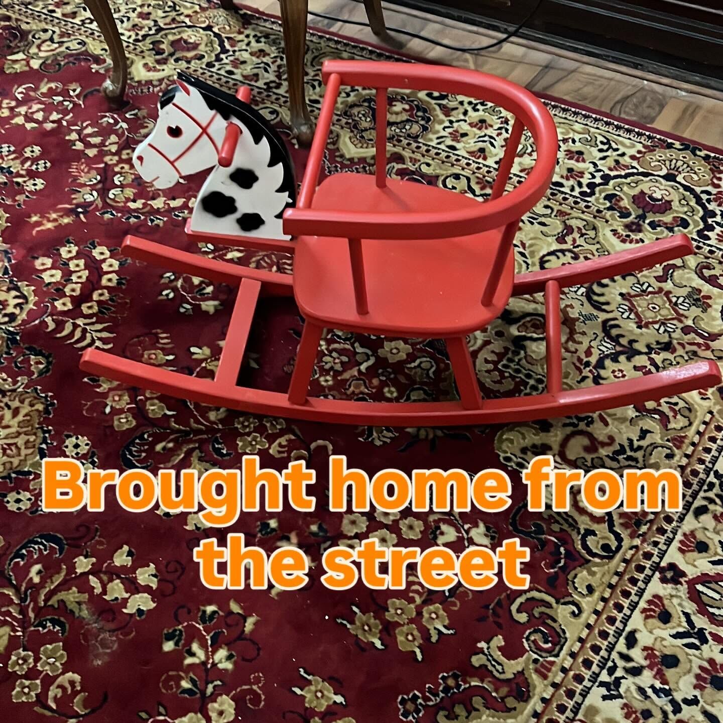 Story frame: a red rocking-horse chair on a rug, captioned Brought home from the street