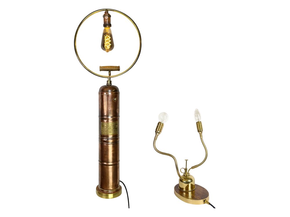 Two lamps made from old garden tools: a copper pump with a bulb in a brass ring, and a small sprayer with two curved arms