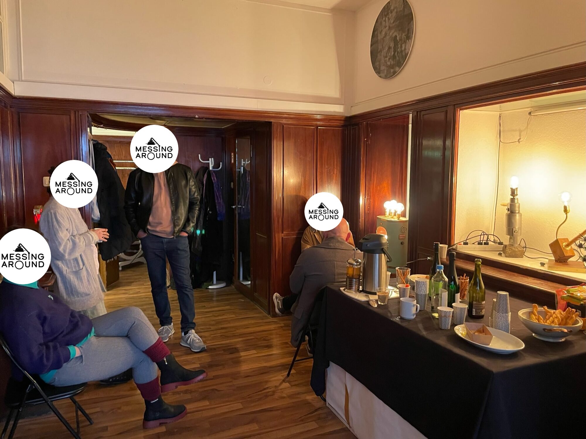 Guests talking at an open studio evening, with lamps lit on a table