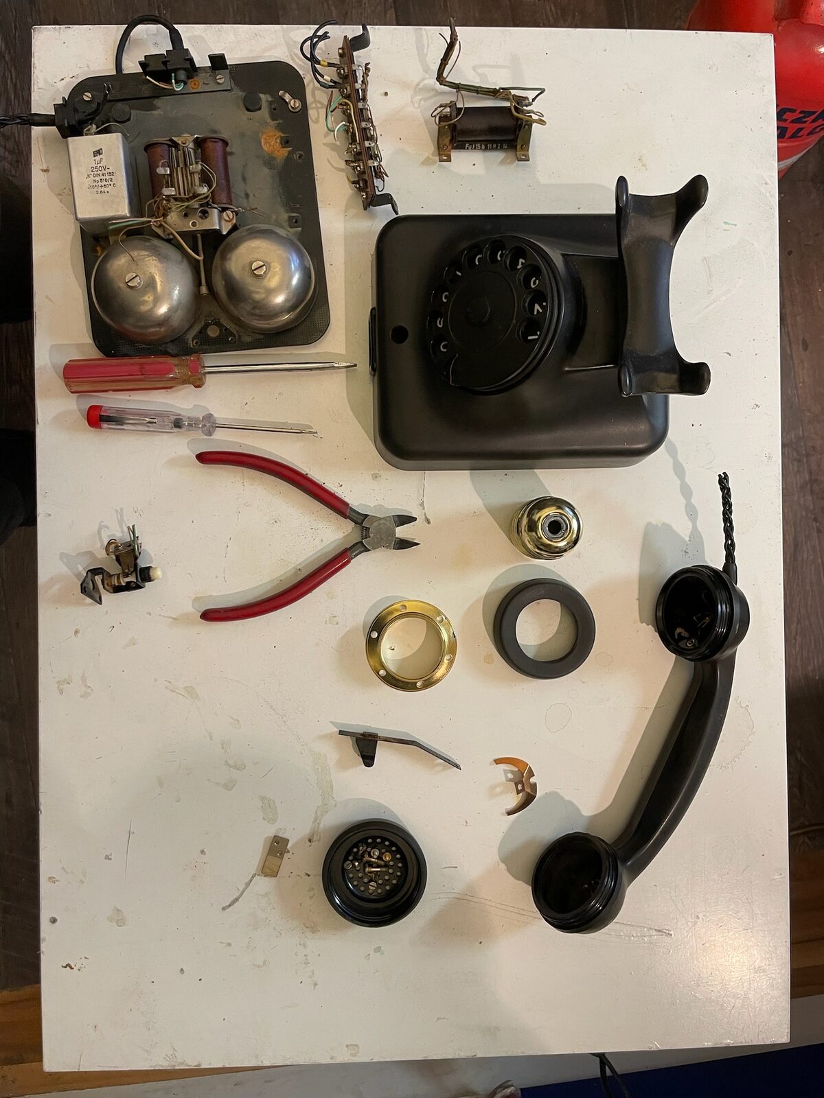 Phone dismantled: bells, dial, handset and rings laid out