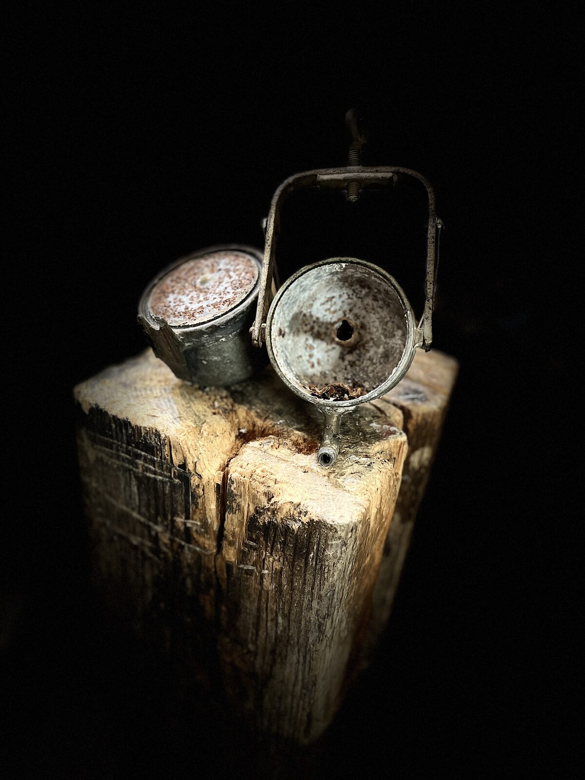 Carbide lamp opened into its two halves on the stump