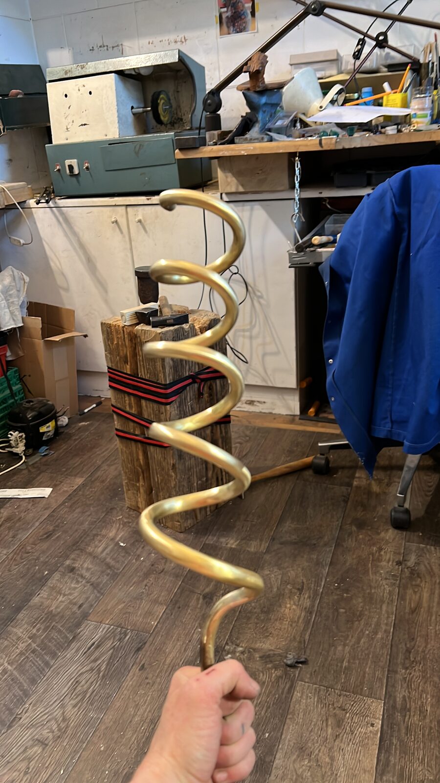 Brass spiral held up in the workshop
