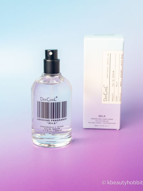 DedCool Milk genderless vegan eau de parfum bottle and box on pastel blue-to-pink background with barcode label and spray top