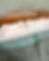 White pillows on a wooden bed with teal bedding. Text reads "SLEEP & GLOW: Omnia vs Aula pillows." Calm, neutral setting.