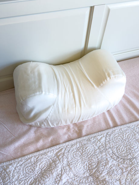 White Aula pillow on a pink bedspread beside a white headboard, with the watermark kbeautyhobbit