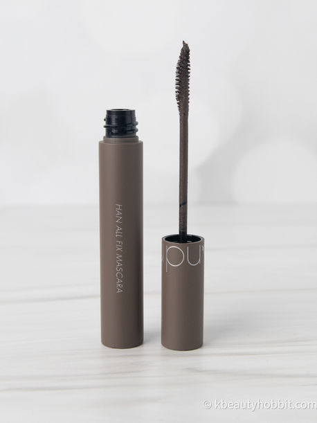 a brown tube of Romand mascara with the lid off and mascara wand clearly visible