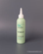 Green Dr.FORHAIR scalp scaler bottle on a gray surface. Blue and black text on the bottle describes benefits for scalp freshness.