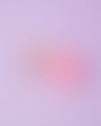 Pink jar of shimmery cream with "Gella’s" text on lid, open on a pastel purple surface, creating a soft, calming mood.