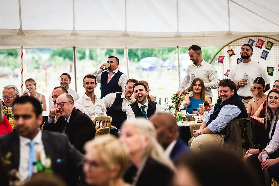 Wedding reception guests listening to speeches in the marquee