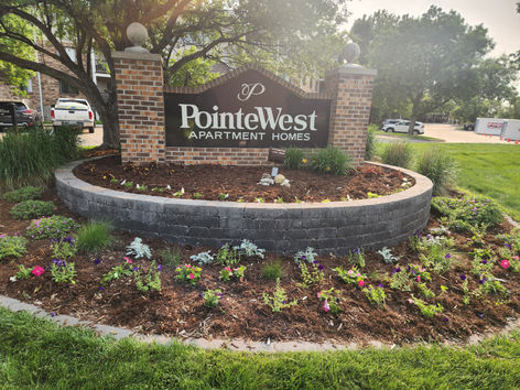 Professional seasonal floral landscaping surrounding the Pointe West monument sign in West Des Moines