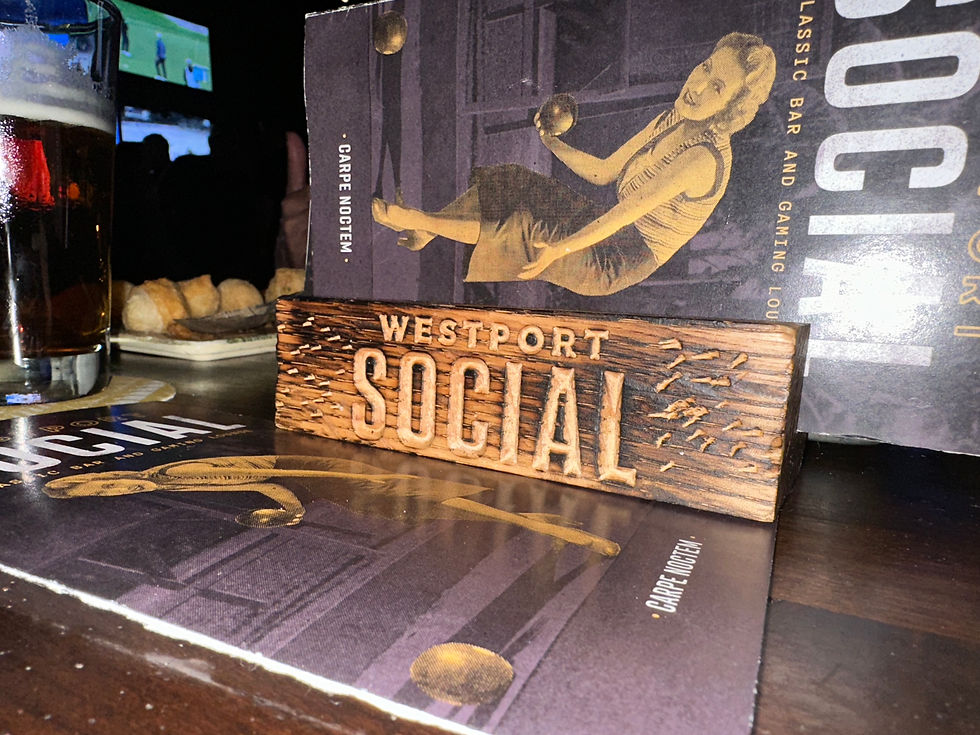 Photo of an engraved wood Wesport Social block holding Westport Social menus.