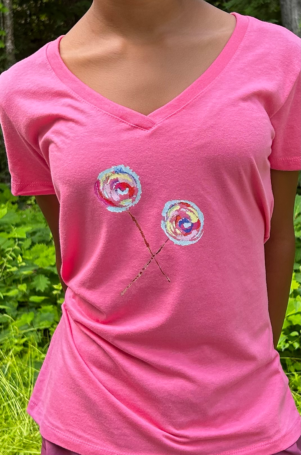 Two lollipops with crossed sticks on a bubblegum pink v-neck women's t-shirt.