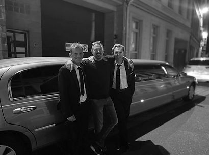 Stefaan en Tony (eigenaars) poseren samen met Axel Daeseleire (klant) voor hun exclusieve limousine.