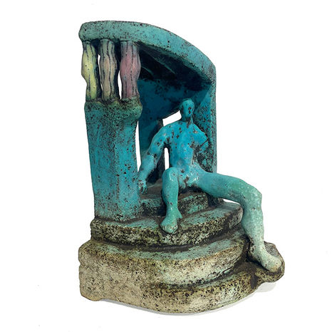 Small abstract ceramic sculpture of a figure resting on a platform in a bright turquoise glaze.