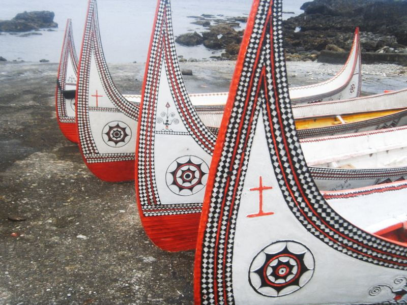 Indigenous boat adorned with spiral patterns, reflecting traditional artistic motifs and the flow of natural energy.