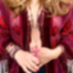 woman with long blond hair in a red boho kimono wearing mala beads and gemstone bracelets