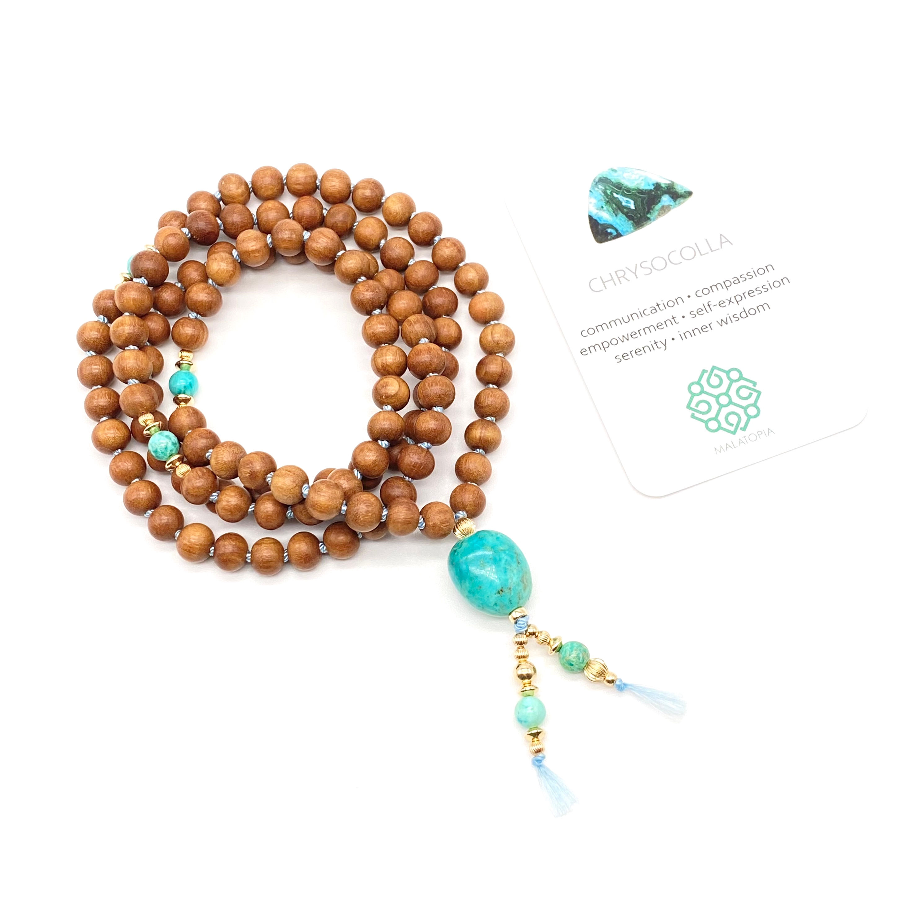 sandalwood and turquoise mala bead necklace arranged in a circle