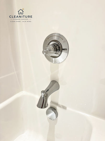 Polished bathtub fixtures after bathroom cleaning