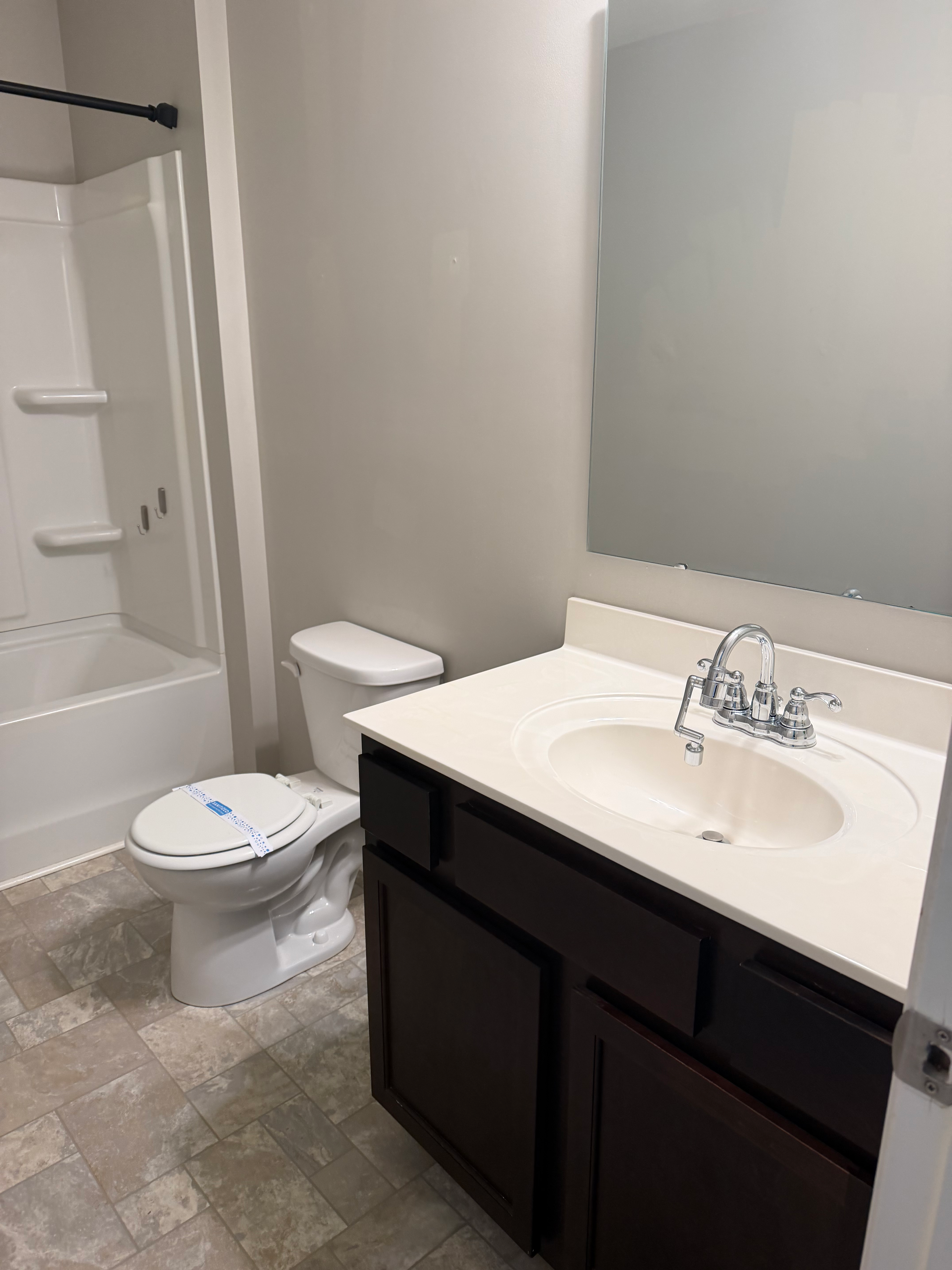 Modern bathroom with white vanity, toilet, and bathtub in Cornelius, NC
