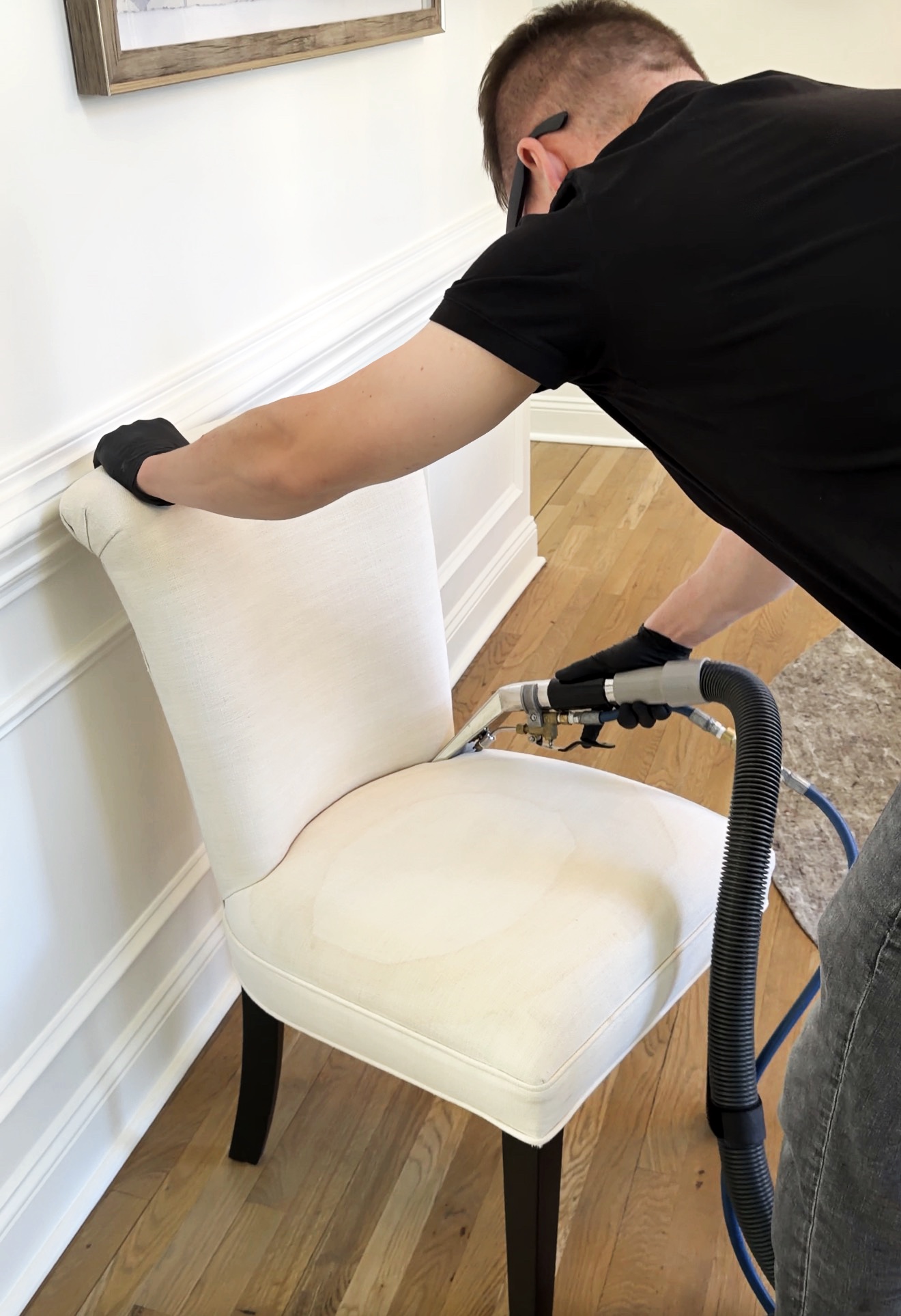 Professional cleaning a white upholstered dining chair in Mooresville, NC