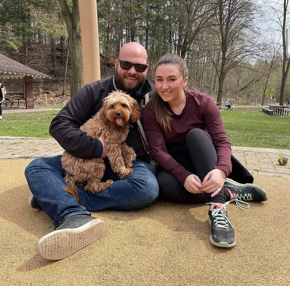 Couple smiling holding brown dog