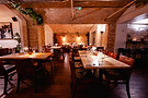 The vault dining room, laid for service beneath brick arches.