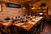 Te vauly dining room laid end to end beneath the brick arches.