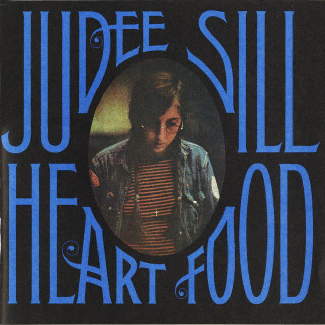 Album cover for Judee Sill’s 1973 album Heart Food, featuring a portrait of Sill against a dark background.