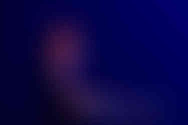 Carla Geneve performing onstage at QPAC Concert Hall, standing with an acoustic guitar under soft, warm lighting.