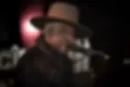 A griining D'Angelo wears a hat