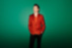 Landscape promo photo of Paul Dempsey, tall dapper man on a lush green background