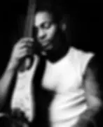 D'Angelo, eyes closed, embraces an electric guitar in glorious black and white