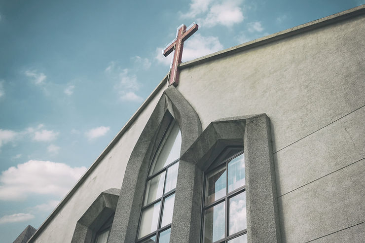 Ausschnitt vor einer Kirche mit einem Kreuz auf dem Dach
