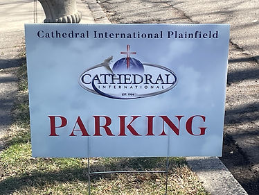 A lawn sign reading "Cathedral International Plainfield PARKING" with their logo.