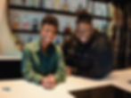 YolanDa Brown and T Oyelola leaning on bar counter, with smiles on their faces