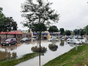 Imagen referencial de automóviles circulando por una calle urbana inundada tras fuertes lluvias.
