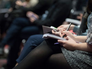 Personas adultas toman apuntes durante una jornada de capacitación.