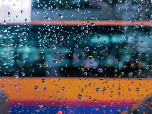 Autobús visto a través de una ventana cubierta por gotas de lluvia.