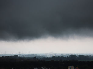 Nubes oscuras de tormenta avanzan sobre una zona urbana.