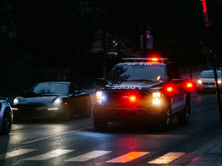 Imagen referencial de un vehículo policial patrullando una calle urbana durante la noche.