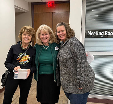 Three women standing side-by-side and smiling into the camera