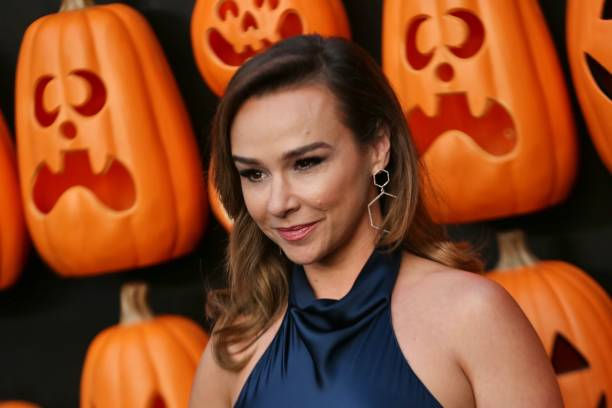 An image of horror actress Danielle Harris surrounded by pumpkins.