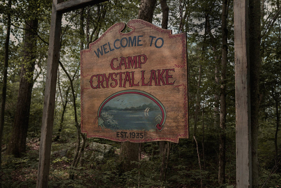 An image of a sign that reads, "Welcome to Camp Crystal Lake" from the TV series Crystal Lake on Peacock.