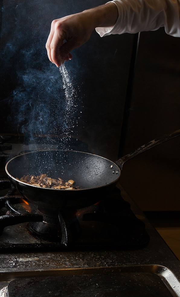 side-view-mushroom-frying-with-salt-fire-human-hand-pan.jpg