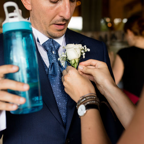 groom getting his boutonniere put on