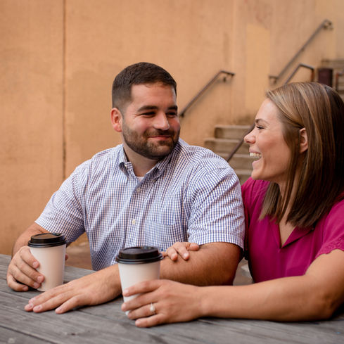 woman wrapping her fiance's arm as they sit together