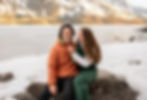 couple sitting on a rock and laughing together