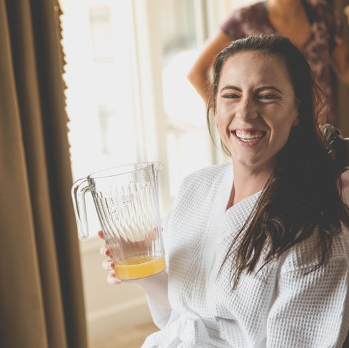 the bride laughing as she has a mimosa