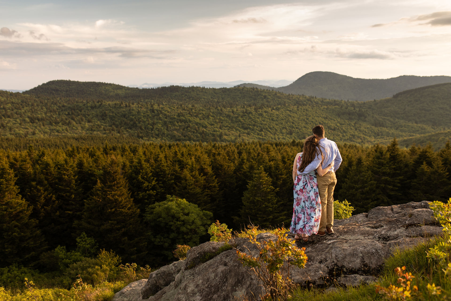 couple looking at the sunset while holding on to each other 