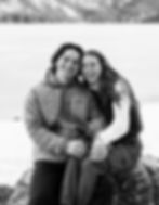couple smiling as they sit together in front of Jenny Lake
